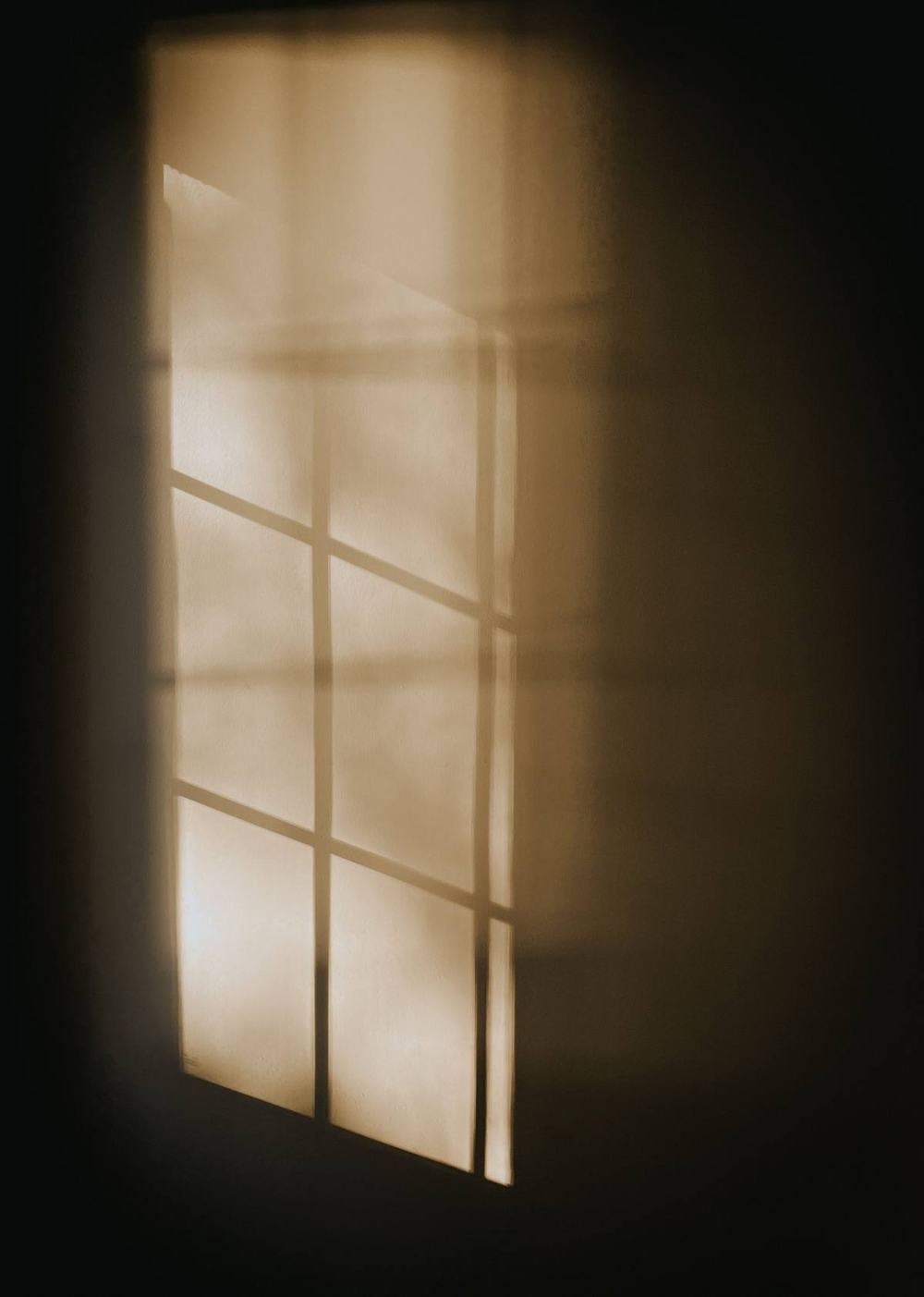 Soft morning light from a window falling on a dark wall