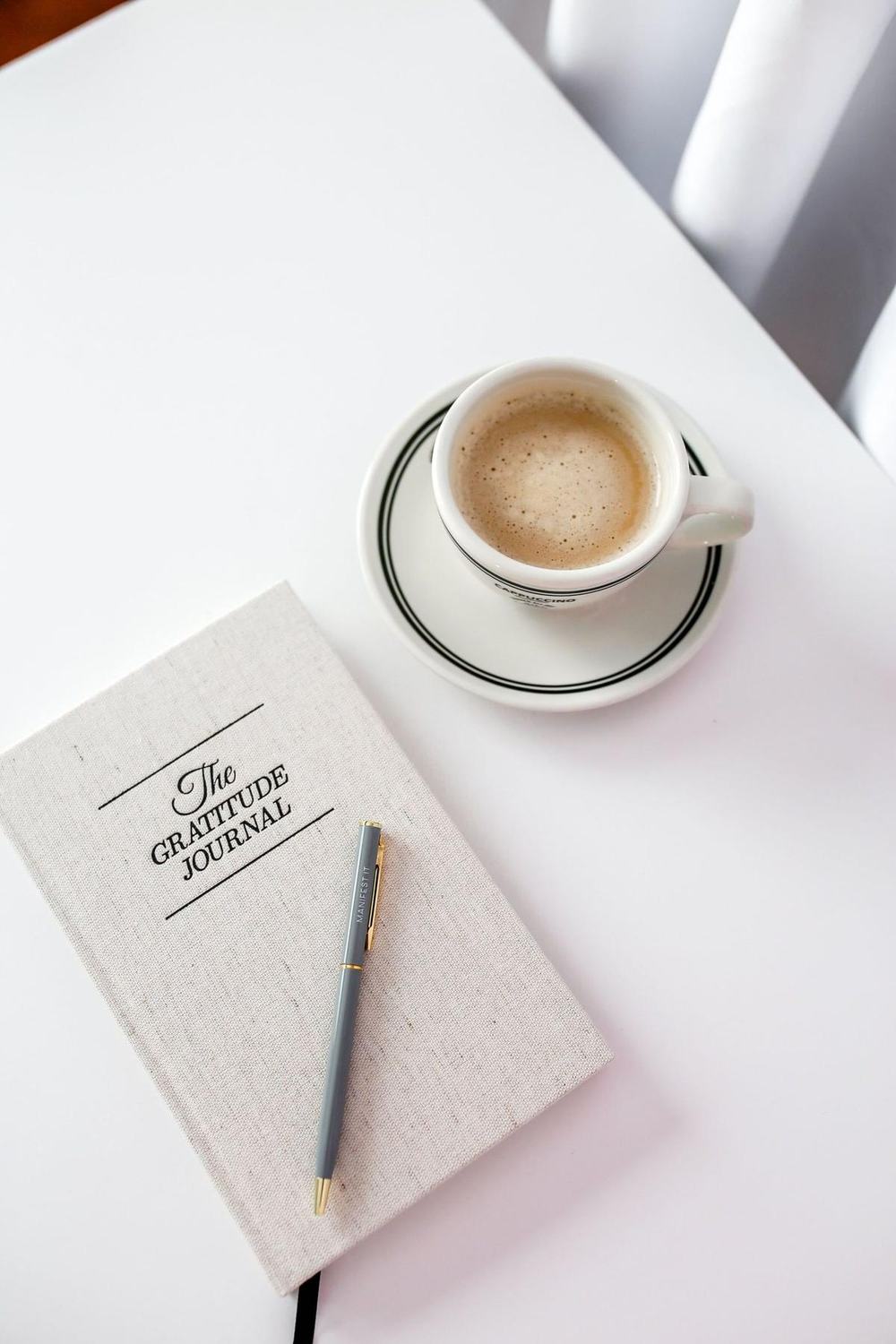 A gratitude journal and a cup of coffee