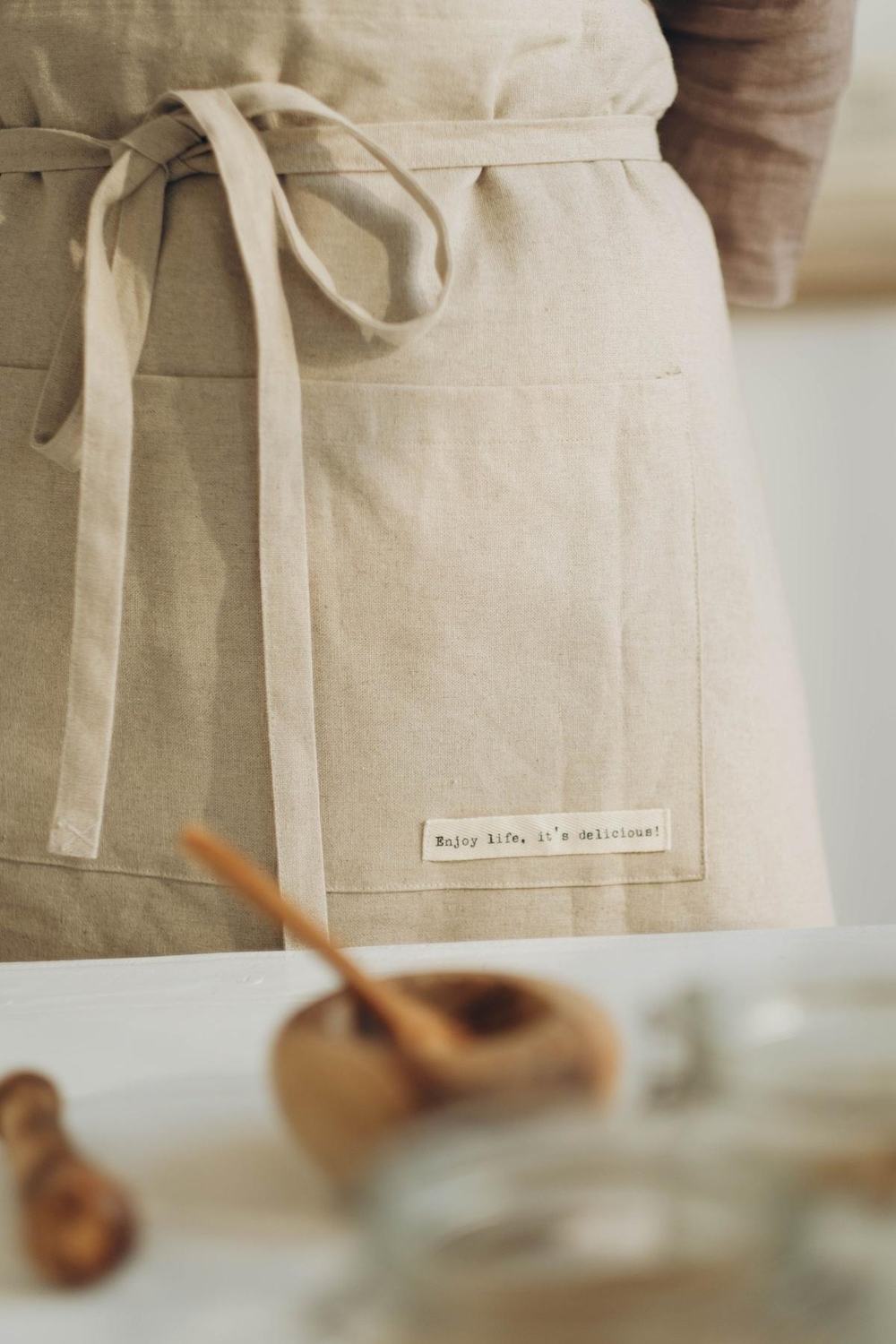 A natural linen apron with ties and a front pocket