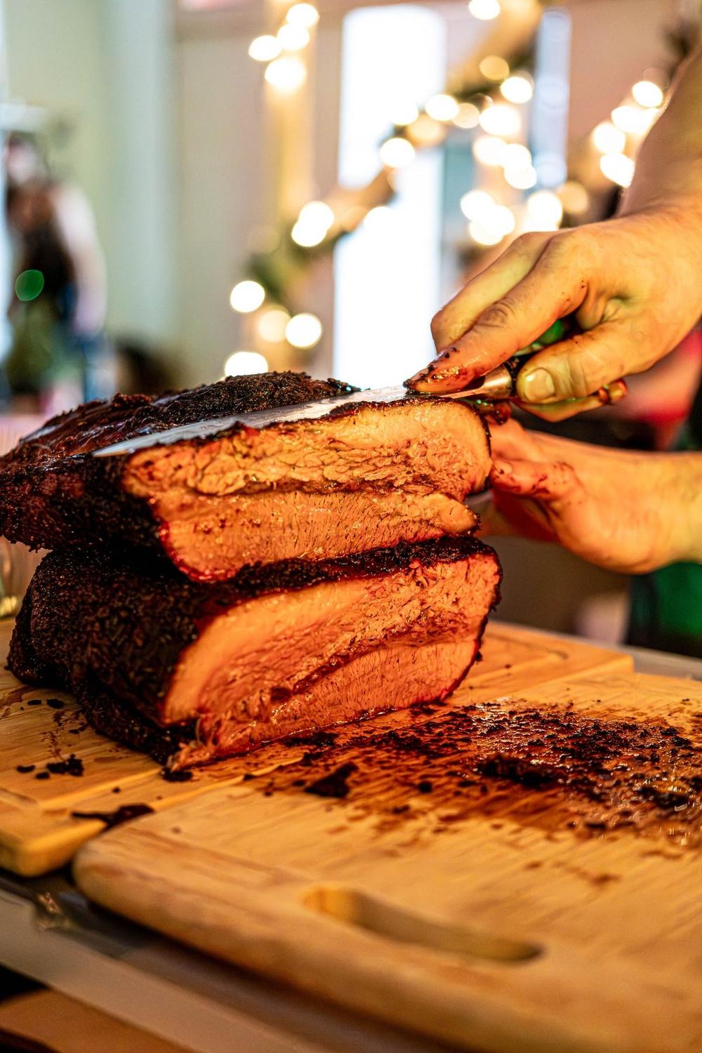 A smoked roast being sliced on a wooden board