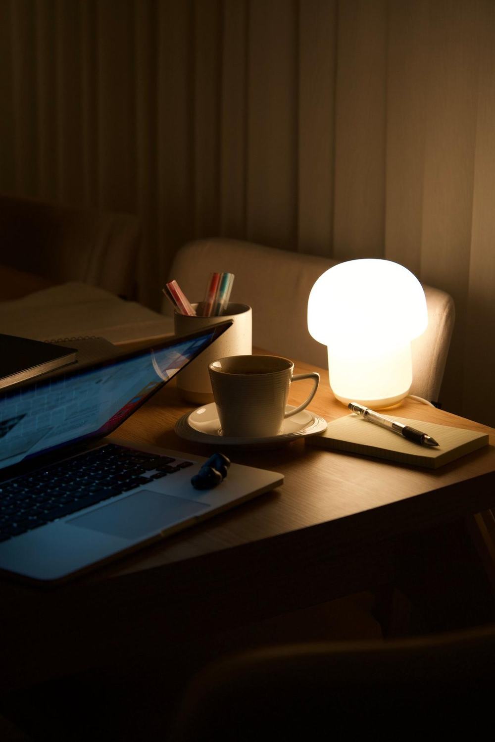 A warm lamp glowing on a desk at night
