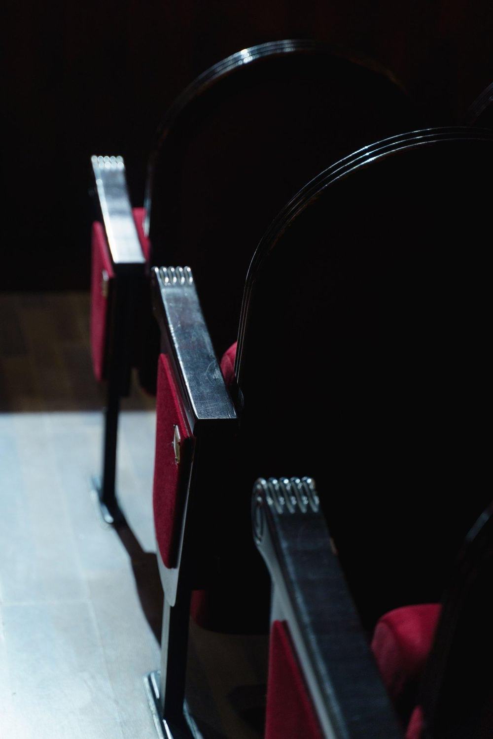 Red velvet theatre seats in the dark